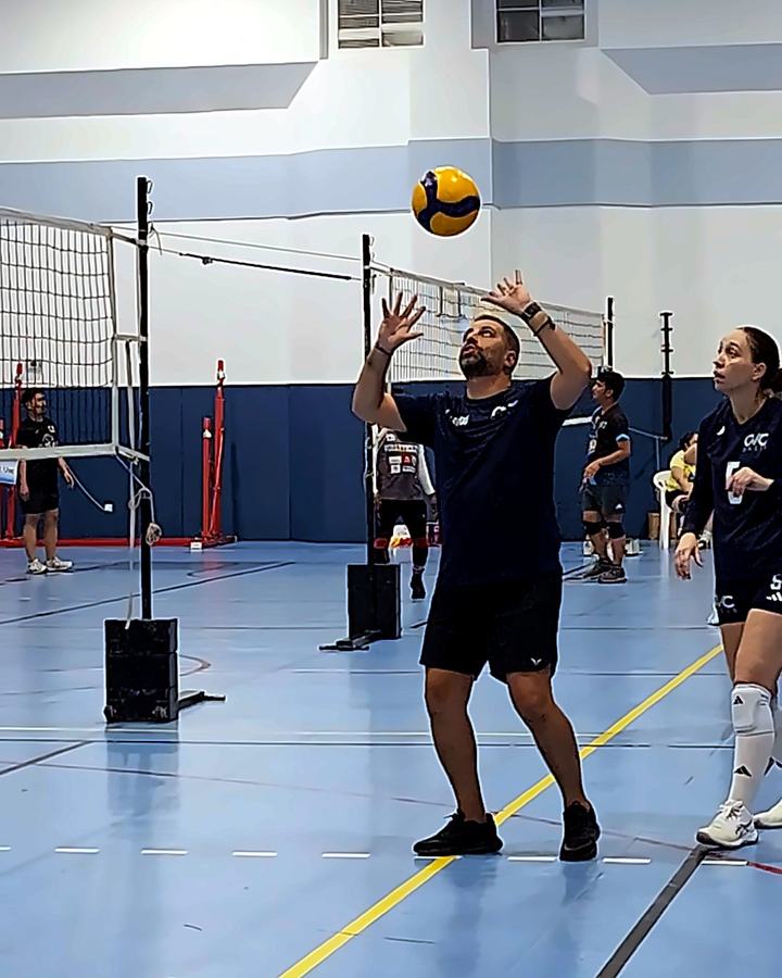 The Oasis coach demonstrating how to set the ball while a player watches