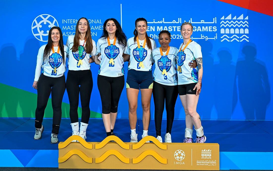 Oasis women's team players in club jerseys on the podium with their medals