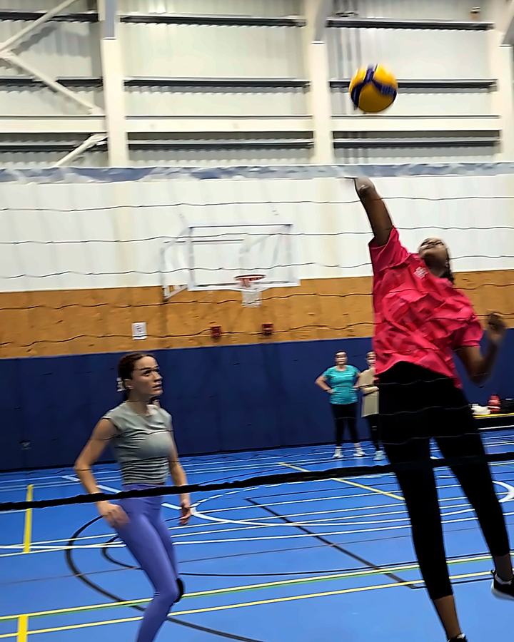 An Oasis player attacking the ball at the net during women's volleyball training in Abu Dhabi